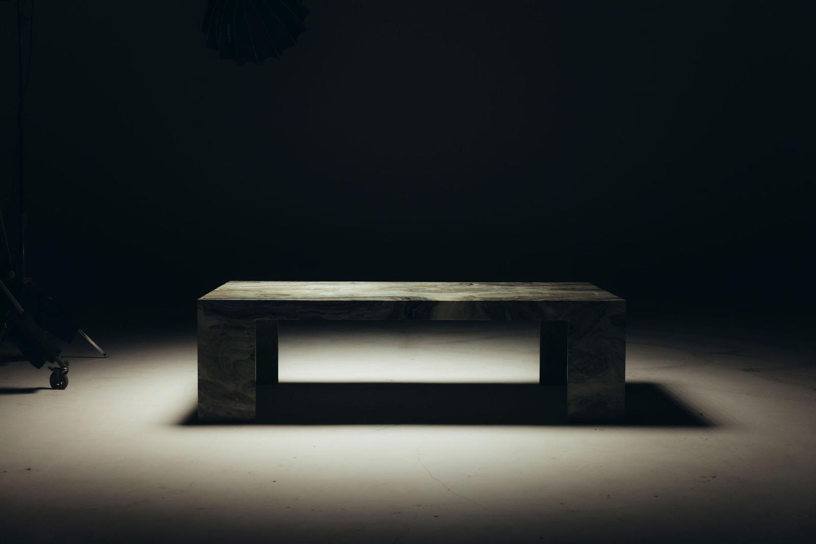 Lage tafel in massief marmer in het licht van een studiolamp