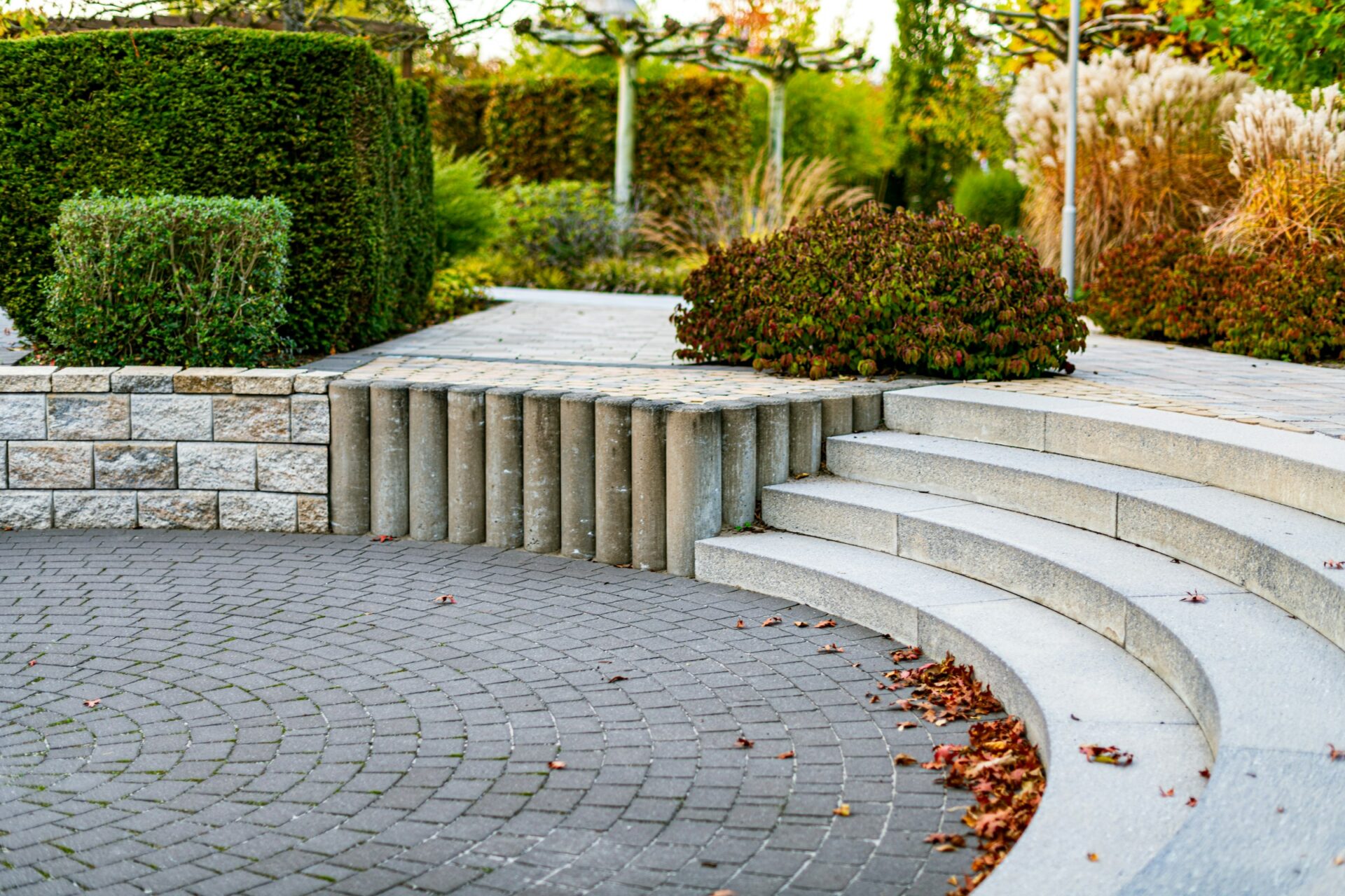 Gebogen traptreden en bestrating van lichte natuursteen in een tuin