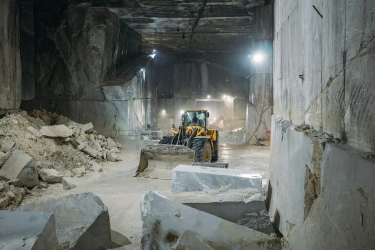 Ondergrondse marmergroeve met een shovel tussen gezaagde marmerblokken