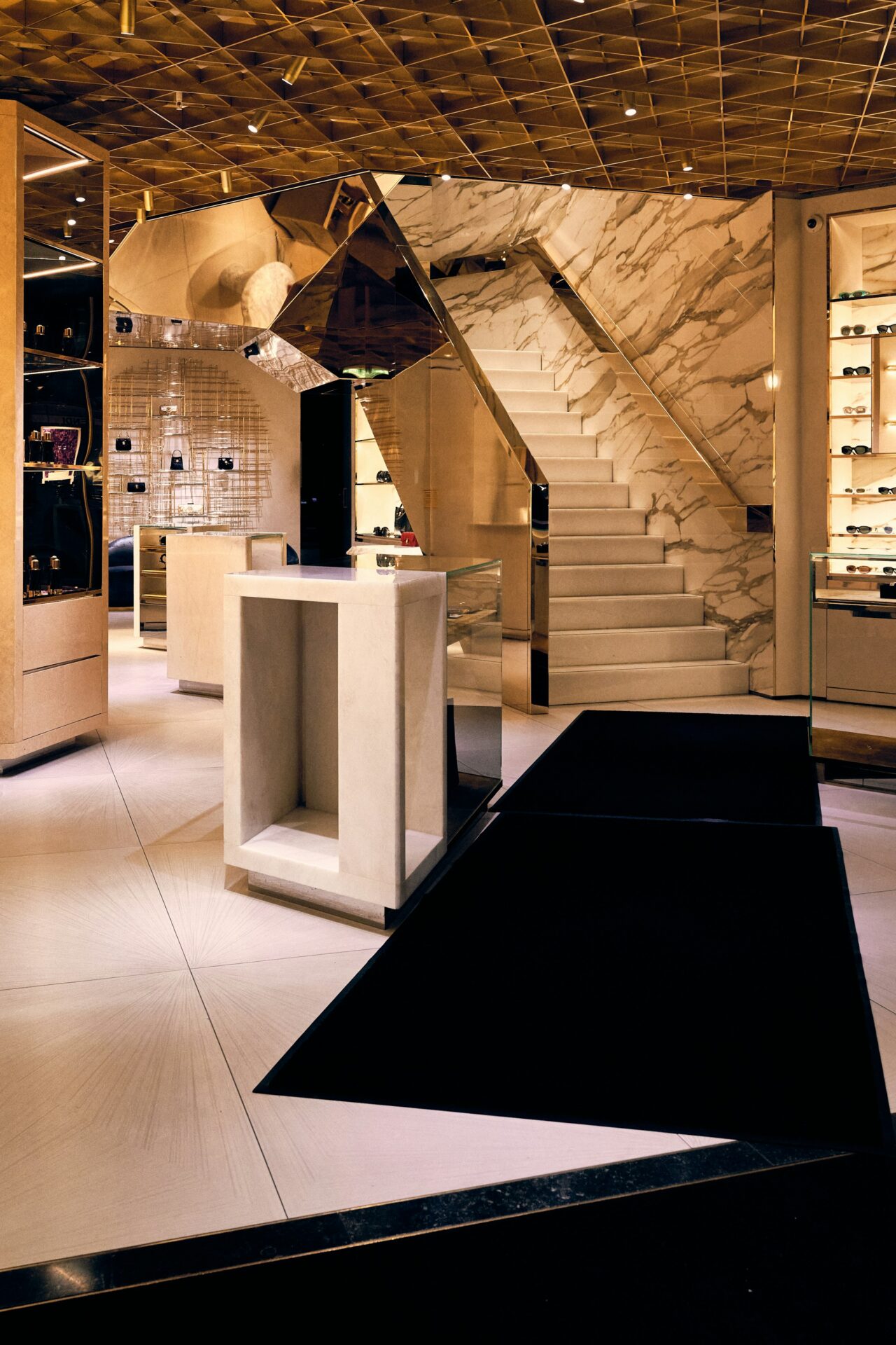 Luxe boetiek met marmeren trap en stenen presentatiemeubels